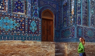 Antichi decori del complesso monumentale di Shah-i-Zinda Una turista ammira i decori di una delle facciate esterne della necropoli di Samarcanda