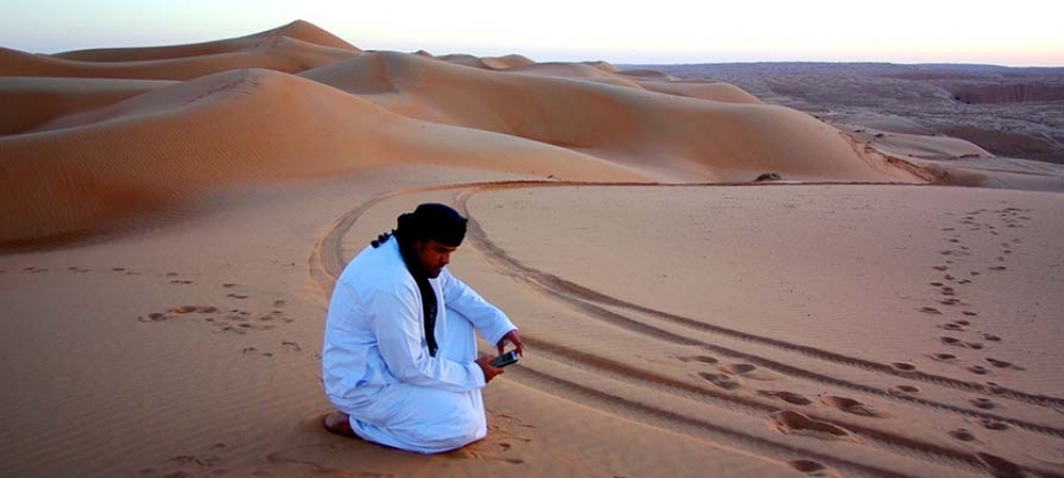 Uomo seduto nel deserto dell'Oman durante il tour di Pasqua in Oman