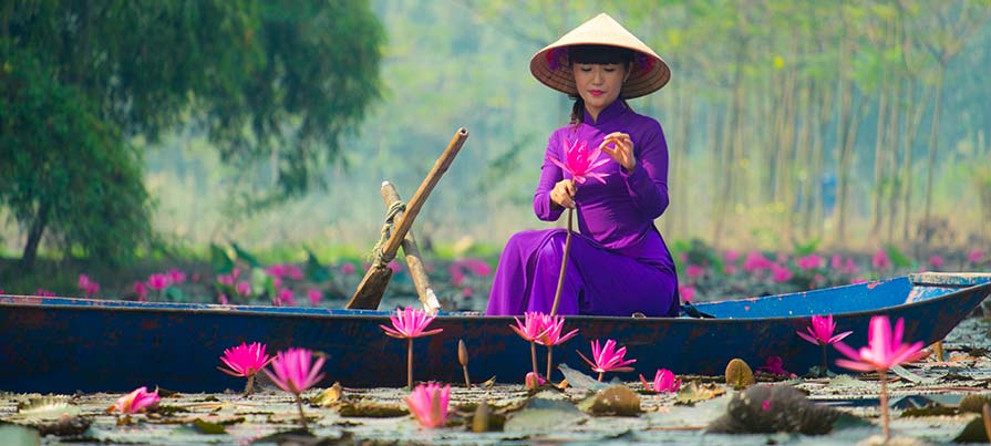 Donna in abito elegante su barca vietnamita durante il tour di 11 giorni Sogno Vietnamita